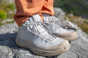 A pair of white hiking boots on a rock