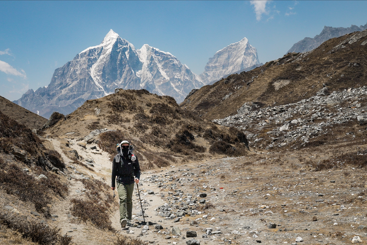 A man hikes in front of mountains in Nepal