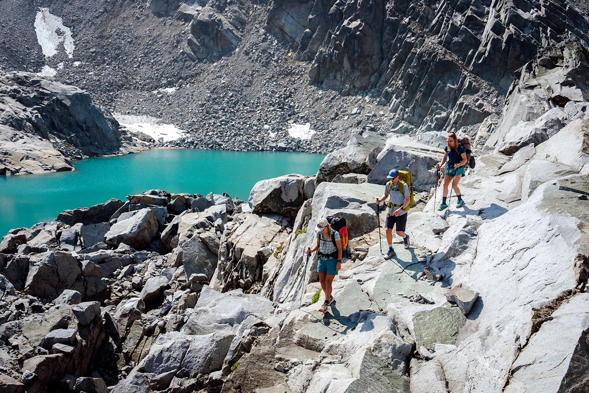 An overview picture of a group hiking above an alpine lake