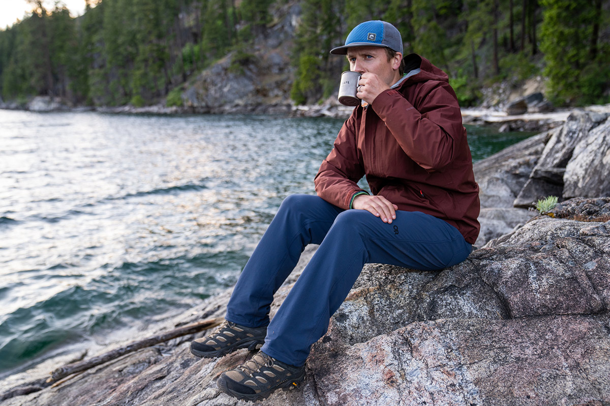 A man drinking coffee by Lake Chelan in the Merrell Moab 3 Mid Hiking Boot
